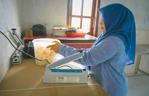 Yuni sedang mengemas produk kerupuk